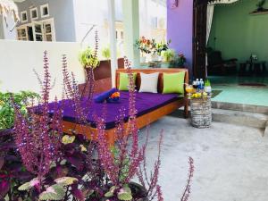 een bed met paarse lakens en kussens op een patio bij An Bang Purple Homestay in Hội An