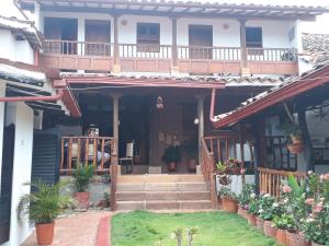 a house with a porch with potted plants on it at Casa Doña Rosaura Barichara ALQUILER Entero in Barichara
