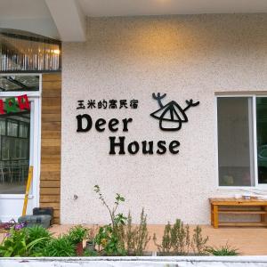 una señal para una casa de ciervos al lado de un edificio en Deer House en Yongan