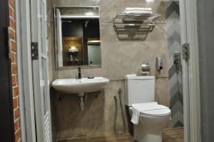 ein Badezimmer mit einem Waschbecken, einem WC und einem Spiegel in der Unterkunft Valya Hotel, Kuala Terengganu in Kuala Terengganu