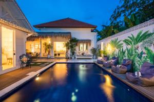 een zwembad in de achtertuin van een huis bij Gypsy Moon Bali in Canggu