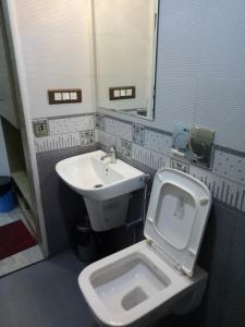 a bathroom with a toilet and a sink at Suroor Tourist Home in Virajpet