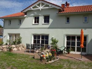 una casa con patio y un patio con flores en Ferienhaus Fischlandperle, en Wustrow