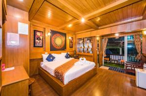 a bedroom with a bed in a wooden room at Baan Ratchapruek in Phuket Town