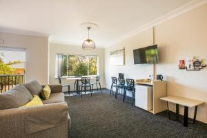 a living room with a couch and a kitchen at Nightcap at Blue Cattle Dog Hotel in Rooty Hill