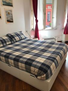 een bed met een zwart-witte plaid deken erop bij New Studio Città Studi in Milaan