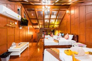 a room with four beds and a tv on a room at Baan Ratchapruek in Phuket