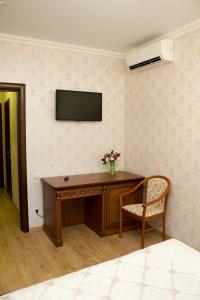セルギエフ・ポサードにあるMini-hotel Kelarskaya Naberezhnayaのデスク、壁掛けテレビが備わる客室です。