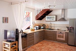 a kitchen with stainless steel appliances and a window at Villa les Alizés in Les Trois-Îlets