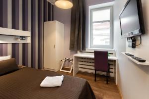 a hotel room with a bed and a desk and a television at Hotel Traffic Poznań Stare Miasto in Poznań