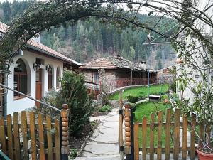 an archway leading to a garden with a house at Guest House Rosenovi in Lyaskovo
