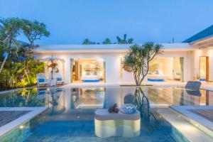 a villa with a swimming pool and a house at Villa Smilla in Seminyak