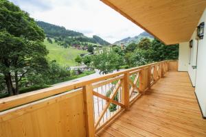 a wooden balcony with a view of the mountains at Landhotel Oberdanner in Saalbach Hinterglemm