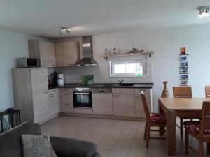 a kitchen with a table and a dining room at Haus am Leuchtfeuer A in Peenemünde