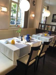 two tables in a restaurant with white table cloth at Hotel Friedrich in Hachenburg
