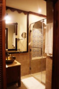 bagno con doccia in vetro e lavandino di Al Koot Heritage Hotel a Al Hofuf