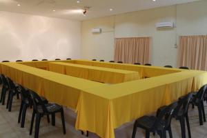 a long yellow table with chairs in a room at Kinabalu Poring Vacation Lodge in Kampung Poring