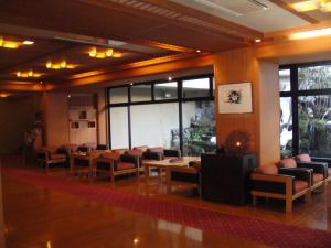 a waiting room with chairs and tables and windows at Ryokan Sakaya in Nozawa Onsen