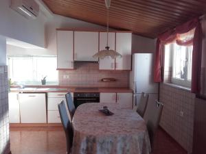 y cocina con mesa, sillas y nevera. en Apartment Frador, en Portorož