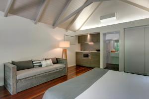 a living room with a couch and a kitchen at Palm Bungalows in Hamilton Island