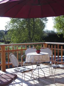 einen Tisch und Stühle auf einer Terrasse mit einem Sonnenschirm in der Unterkunft SchlossparkFerienwohnungen Rheinsberg in Rheinsberg
