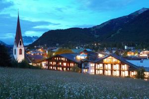 ein Gebäude auf einem Hügel mit einer Kirche in der Unterkunft Alpenlove - Adult SPA Hotel in Seefeld in Tirol