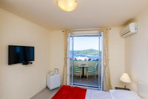 1 Schlafzimmer mit einem Bett und einem Balkon mit einem Tisch in der Unterkunft Deluxe Sunset Room, view of the Old Town in Dubrovnik