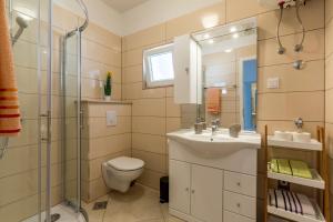 ein Badezimmer mit Waschbecken, Toilette und Dusche in der Unterkunft Apartments Petra in Bol