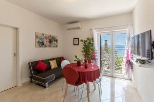ein Wohnzimmer mit einem roten Tisch und einem Sofa in der Unterkunft Apartments Petra in Bol