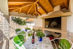 eine Terrasse mit einem Tisch, Stühlen und einem Kamin in der Unterkunft Apartments Petra in Bol