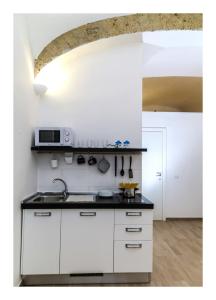 een keuken met witte kasten en een aanrechtblad bij Centro Storico Napoletano in Napels