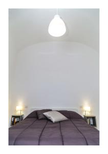 a white bedroom with a large bed with a white pillow at Centro Storico Napoletano in Naples