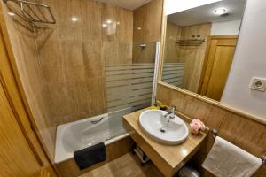 a bathroom with a sink and a mirror and a tub at WonderStays Apartamentos La Estación in Málaga +101 photos