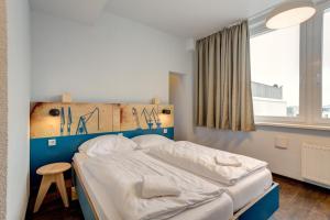 Säng eller sängar i ett rum på MEININGER Hotel Hamburg City Center