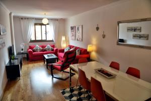 a living room with a red couch and a table at WonderStays Apartamentos La Estación in Málaga