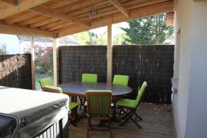 a patio with a table and chairs and a fence at ENTRE LOIRE ET CHER "Le Sologn'Eau" Gîte & SPA Privatif in Tour-en-Sologne