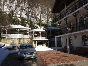a car parked in a parking lot next to a building at Pension Casa Alba in Slănic-Moldova