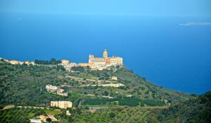 a building on top of a hill next to the ocean at Tindari Village Camping in Furnari