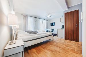 a bedroom with a bed and a wooden floor at Apartamenty Sun & Snow Villa Klif in Jastrzębia Góra