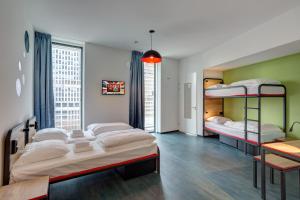 a bedroom with three bunk beds and a table at MEININGER Hotel Amsterdam Amstel in Amsterdam +31 photos