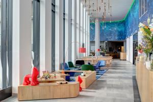 an office with chairs and tables and windows at MEININGER Hotel Amsterdam Amstel in Amsterdam