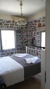 a bedroom with a large bed in a stone wall at Miki's Castle in Láyia