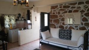 a living room with a couch and a stone wall at Miki's Castle in Láyia