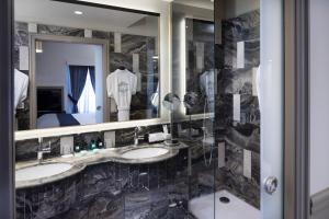 a bathroom with two sinks and a mirror at Hotel Lumen Paris Louvre in Paris