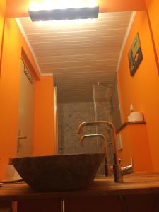 a sink in a bathroom with an orange wall at Guesthouse Marko in Bled