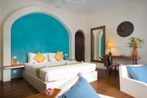 a bedroom with a large bed with a blue wall at Navutu Dreams Resort & Wellness Retreat in Siem Reap