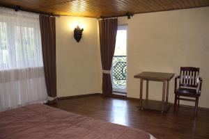 a bedroom with a bed and a table and a window at Smotrytska Vezha in Kamianets-Podilskyi