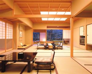 a living room with a table and chairs at Kotohira Onsen Kotosankaku in Kotohira