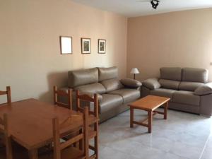 a living room with a couch and a table at Apartamentos Copacabana Playa in La Manga del Mar Menor
