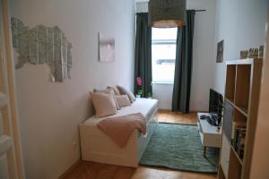 グラーツにあるlovely apartment in the heart of Grazのソファと窓が備わる小さな客室です。